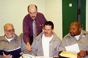 Joe Marinello (standing), contracted instructor 
at Albemarle Correctional Institution, talks with inmates Larry Phifer (from left to right), James Rogers and Walter McDowell. 
The inmates recently graduated from S.T.O.P. and Change Direction, a program aimed at educating offenders about domestic violence.